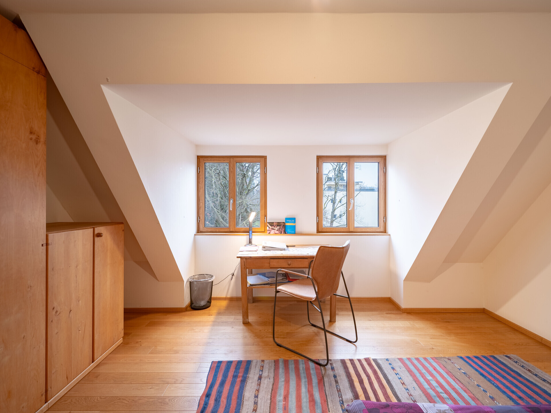 Dachgeschoss-Arbeitszimmer mit Holzfenstern