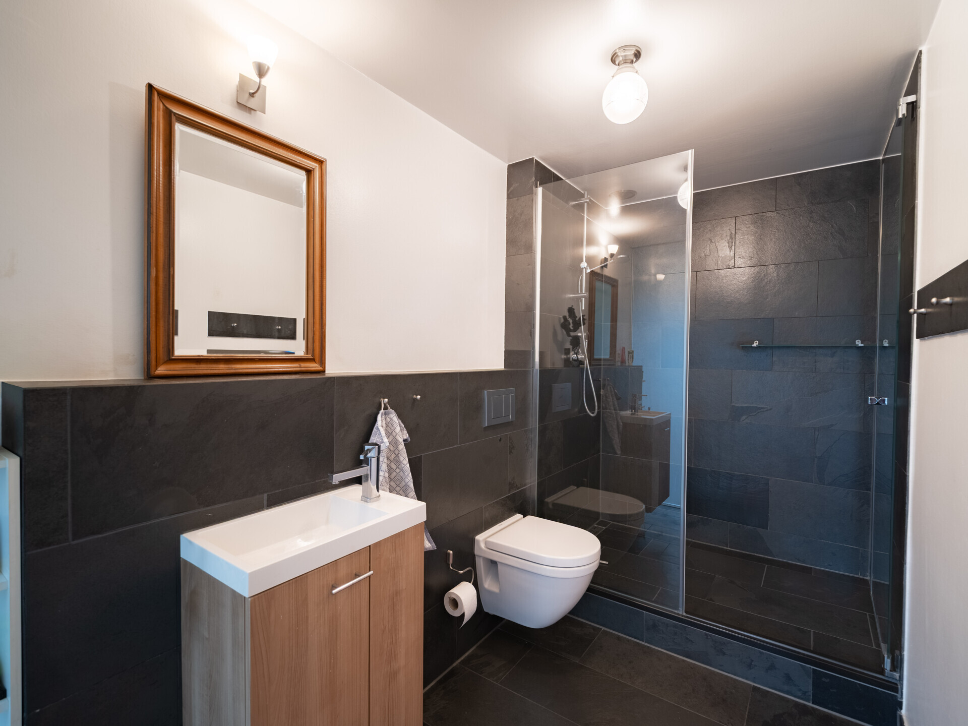 Modernes Badezimmer mit dunklen Fliesen