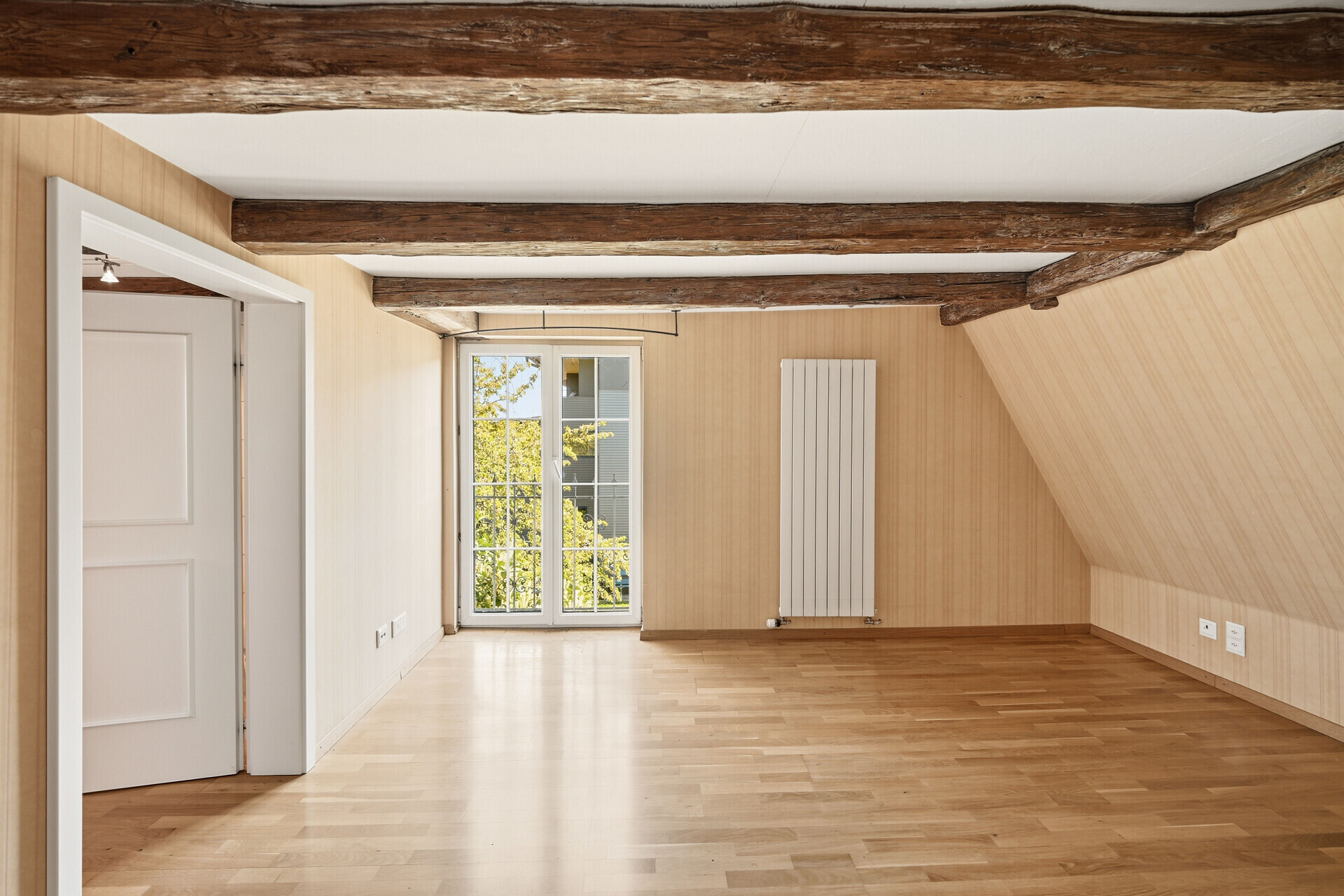 Leerer Dachgeschossraum mit sichtbaren Holzbalken