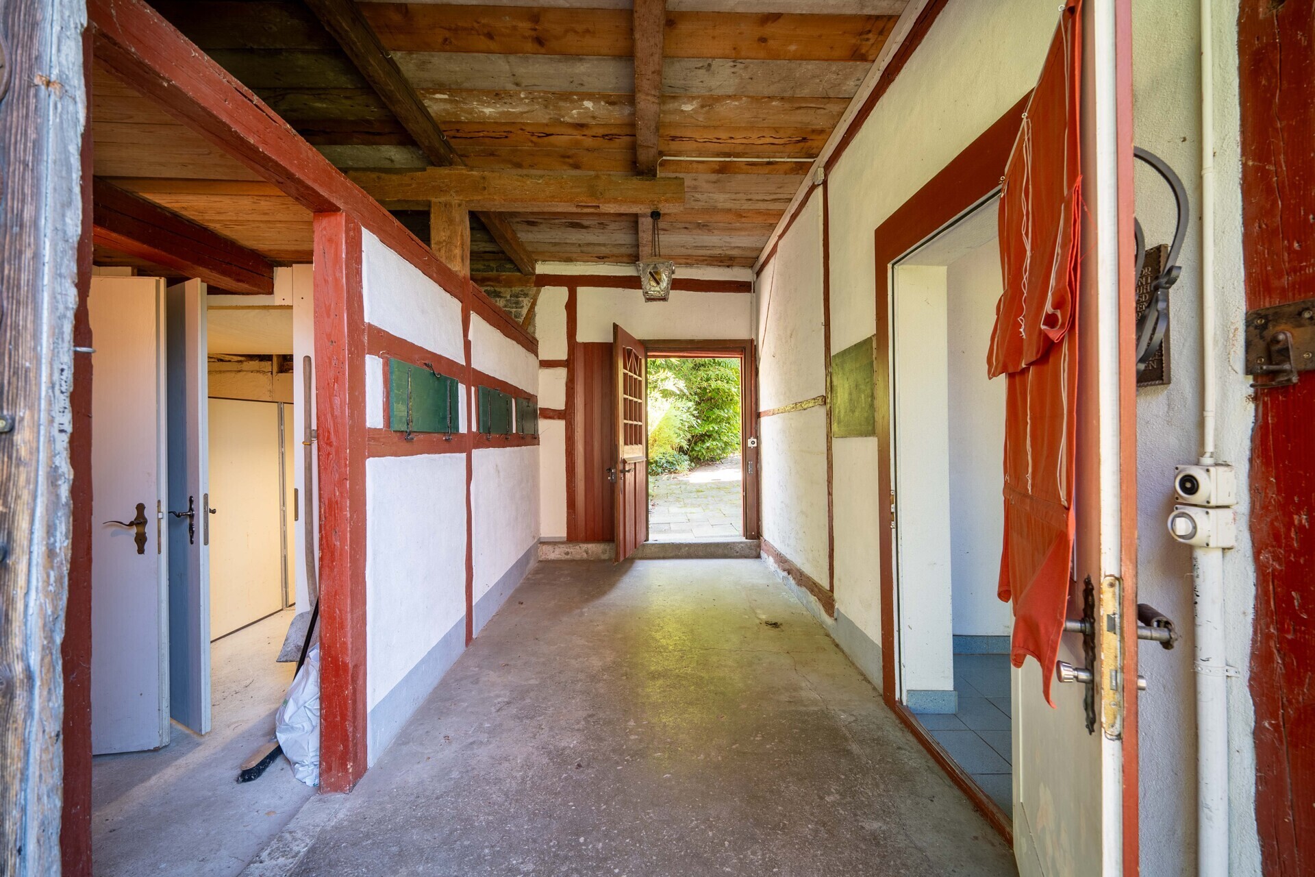 Rustikaler Flur mit Holzbalken und offenem Ausgang