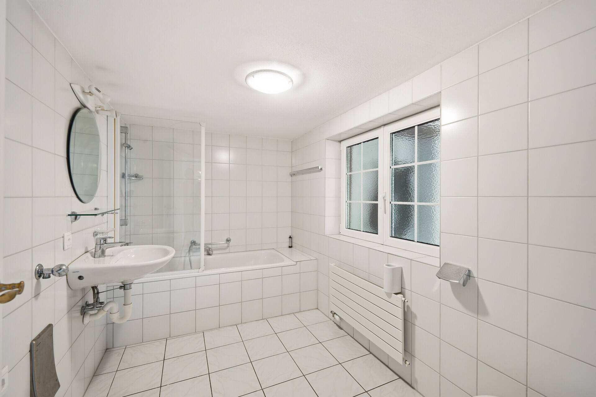 Helles Badezimmer mit Badewanne und Fenster