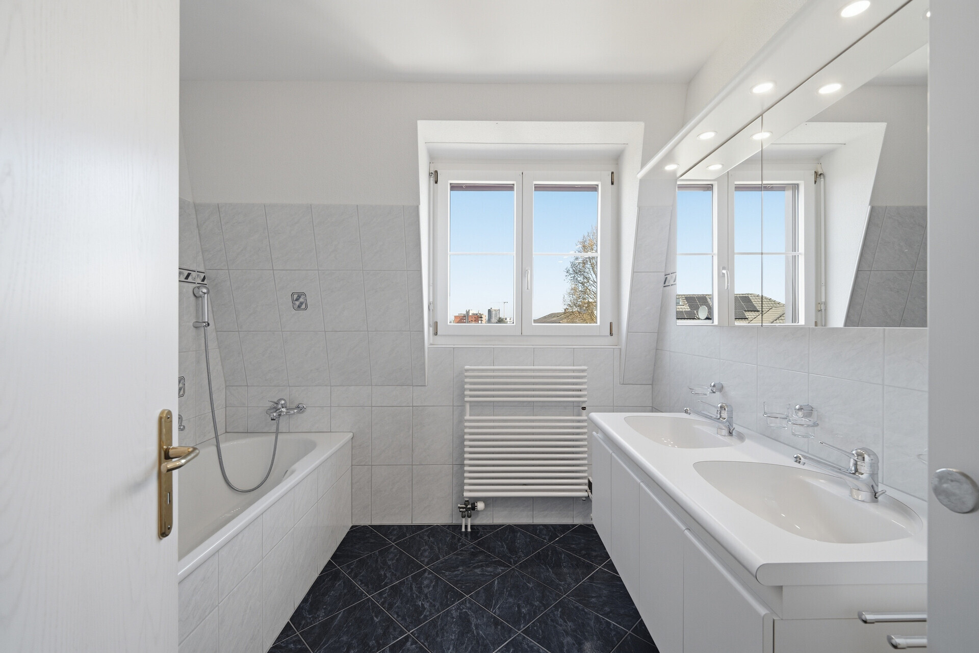 Helles Badezimmer mit Badewanne und Doppelwaschtisch