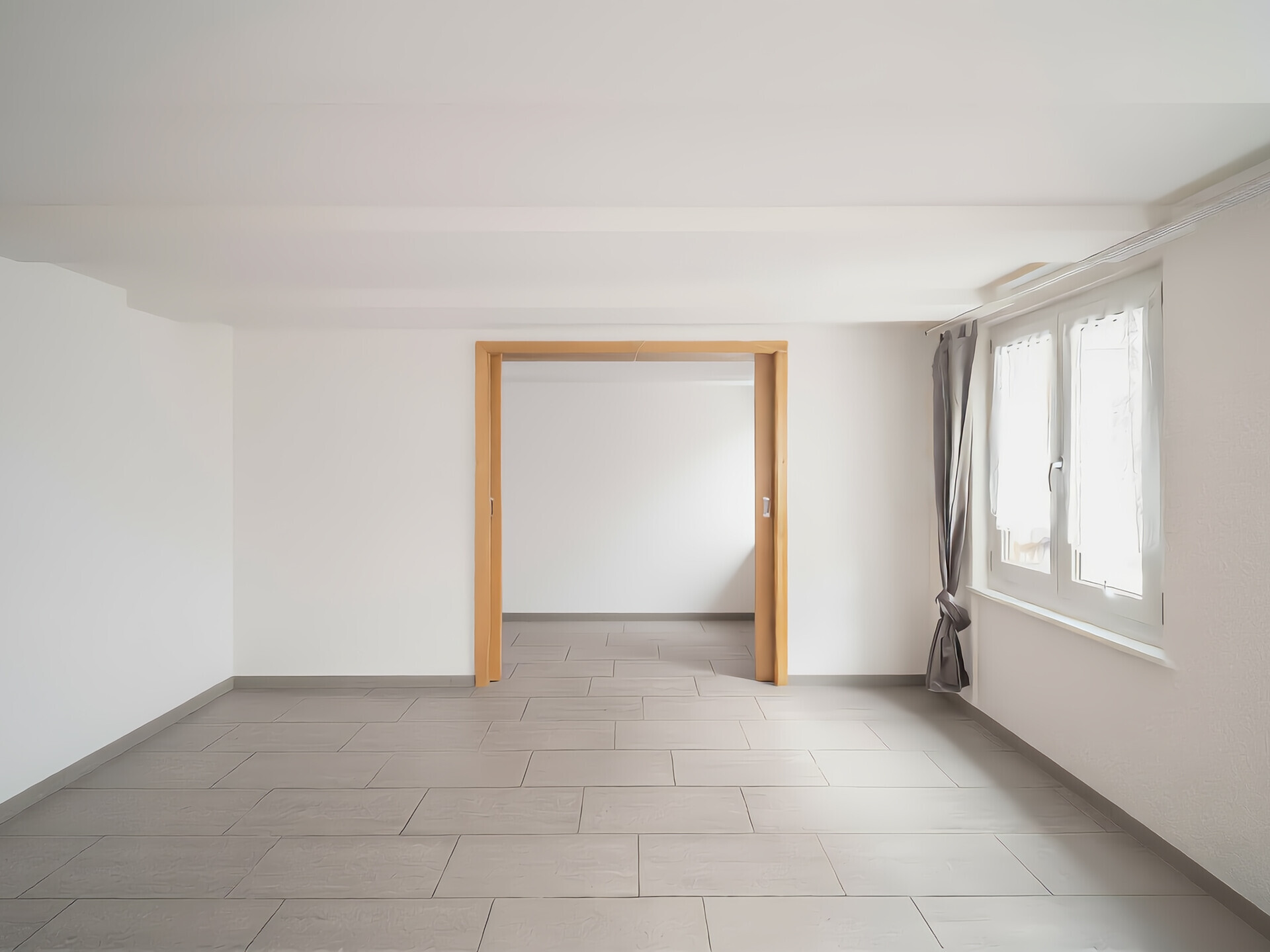 Heller leerer Raum mit Fliesenboden und Fensterfront