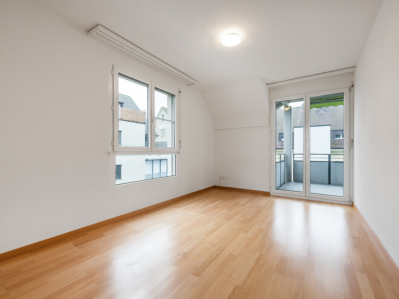 Heller leerer Raum mit Balkon und großen Fenstern