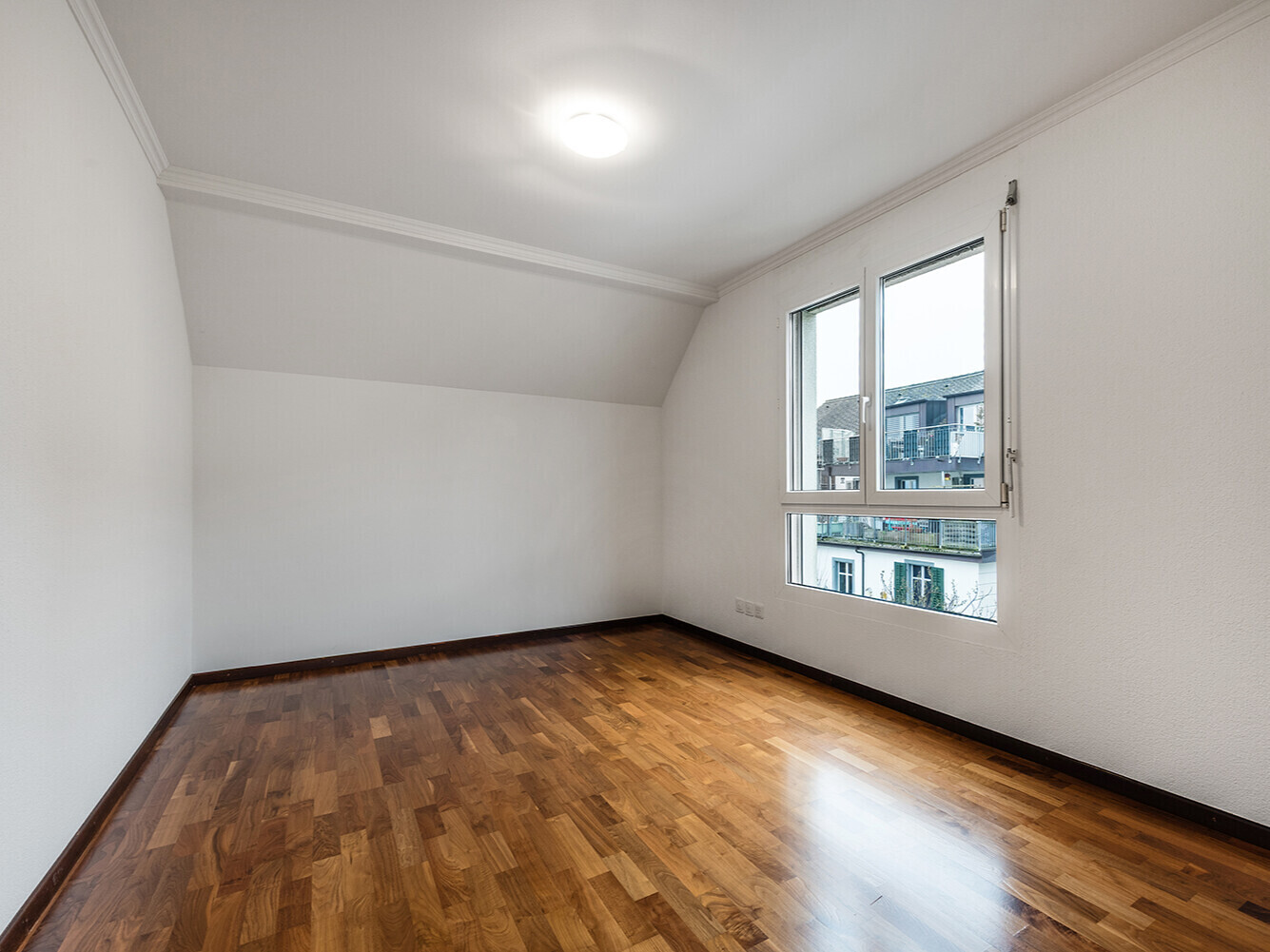 Helles leeres Zimmer mit Holzfußboden