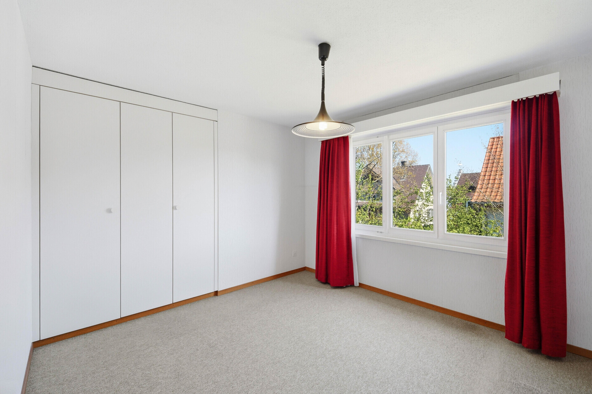 Helles Schlafzimmer mit Einbauschrank und Fensterblick
