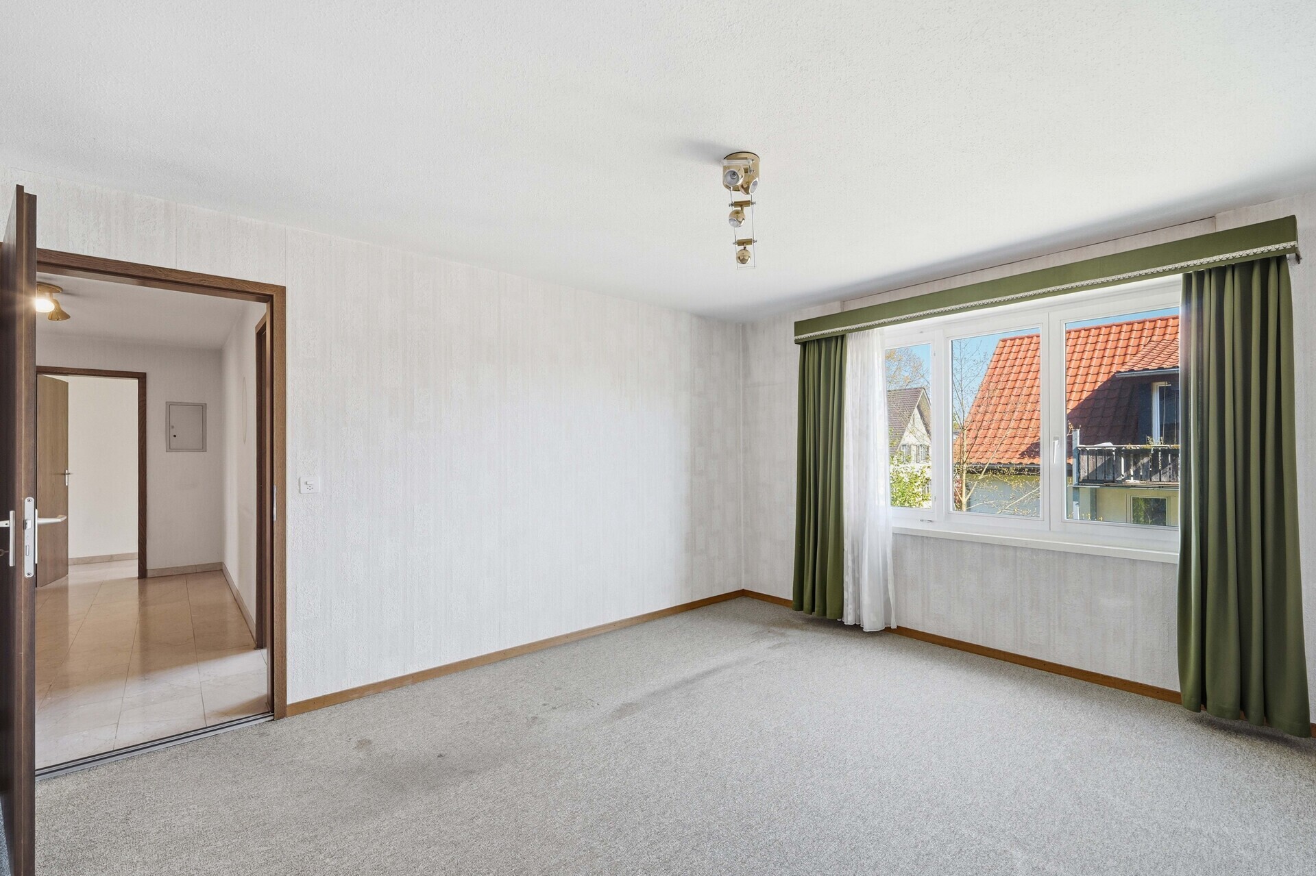 Helles, leer wirkendes Zimmer mit Blick nach draußen