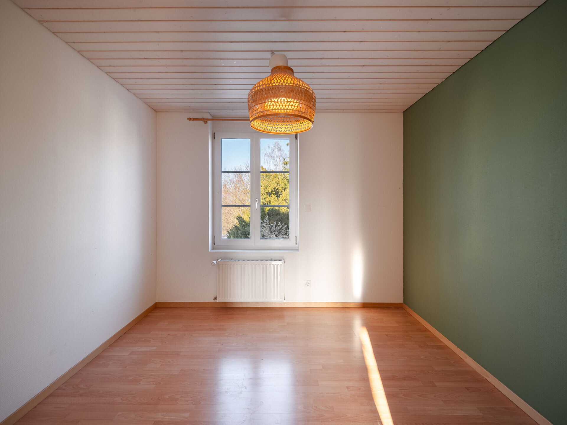 Leeres Zimmer mit Fenster und Pendelleuchte