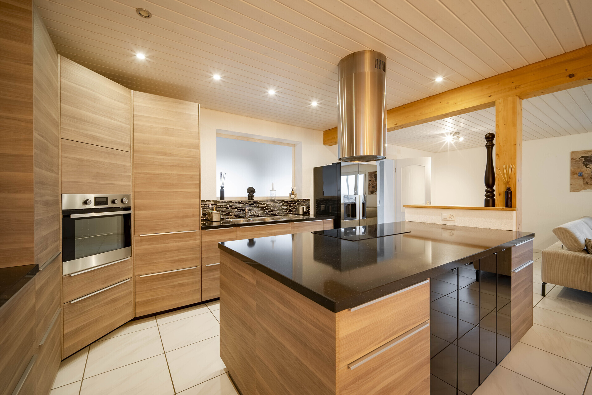 Moderne Küche mit Holzfronten und schwarzer Kochinsel