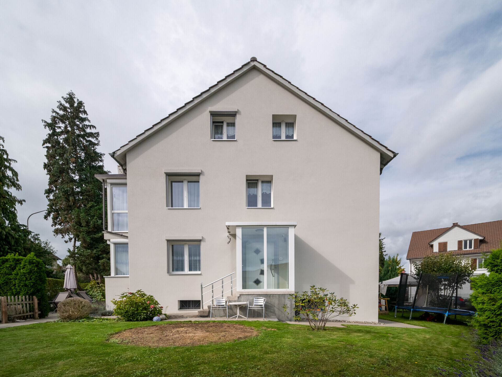Einfamilienhaus mit Satteldach und Gartenansicht