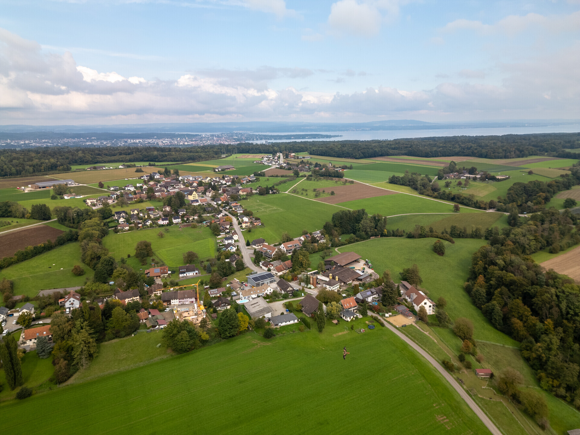 Luftaufnahme einer ländlichen Siedlung mit Seenblick