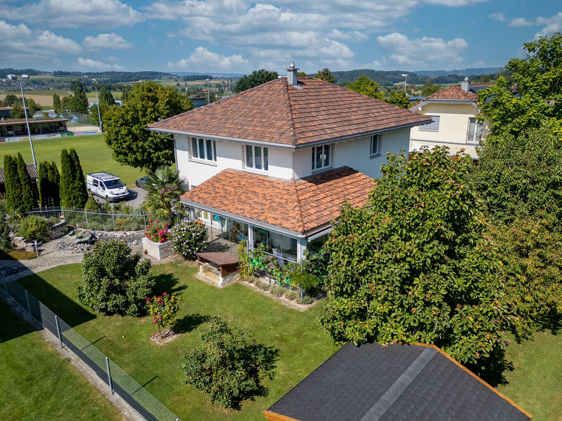 Aussicht auf ein Einfamilienhaus mit Garten und Terrakotta-Dächern