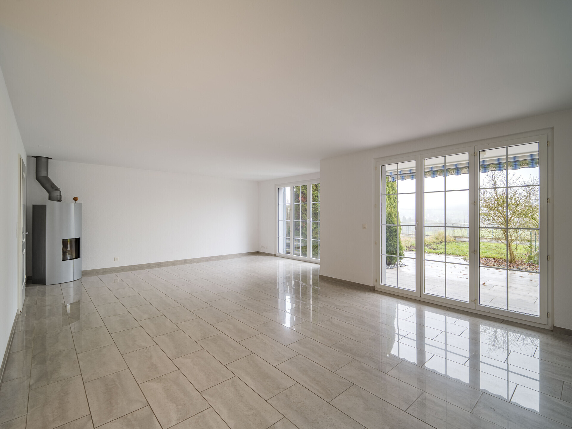 Heller Wohnraum mit großen Fenstern und Kamin