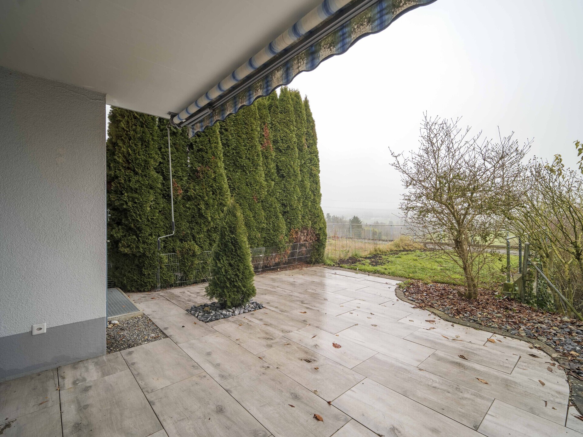 Überdachte Terrasse mit Gartenblick