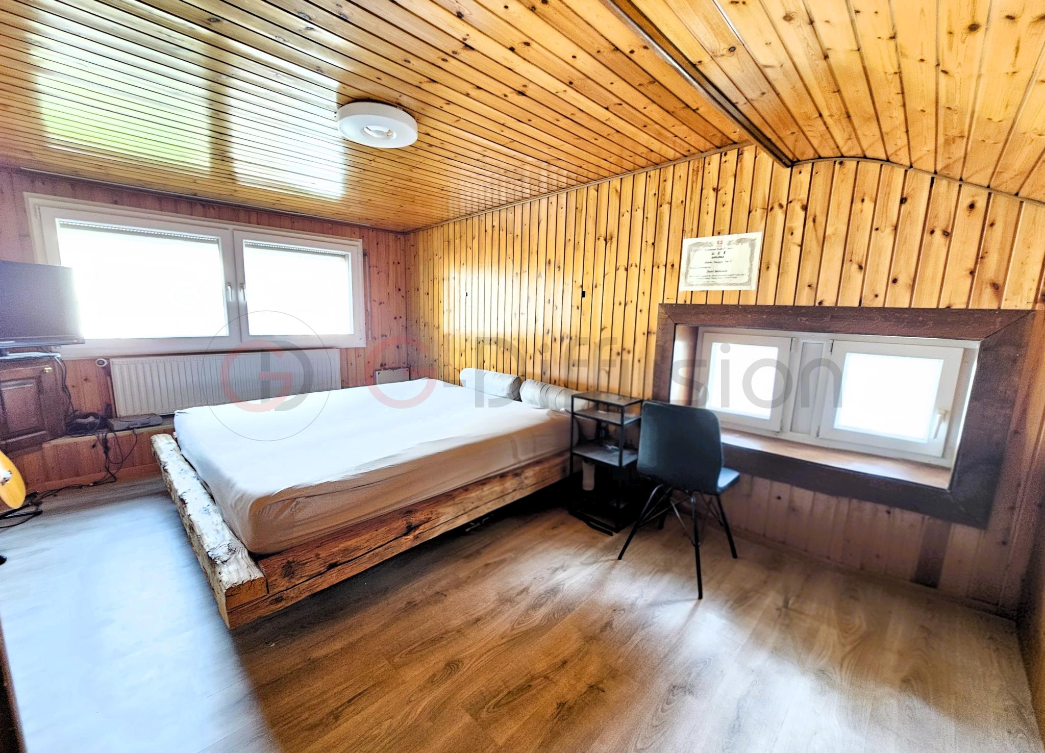 Gemütliches Schlafzimmer mit Holzvertäfelung