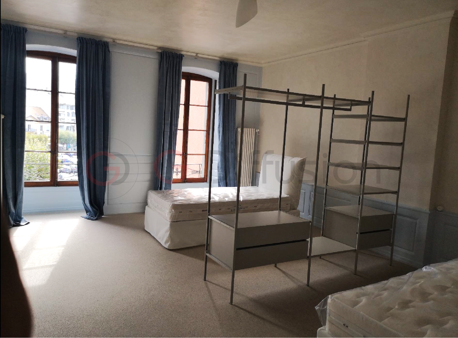 Leeres Schlafzimmer mit zwei Fenstern und Kleiderstangen