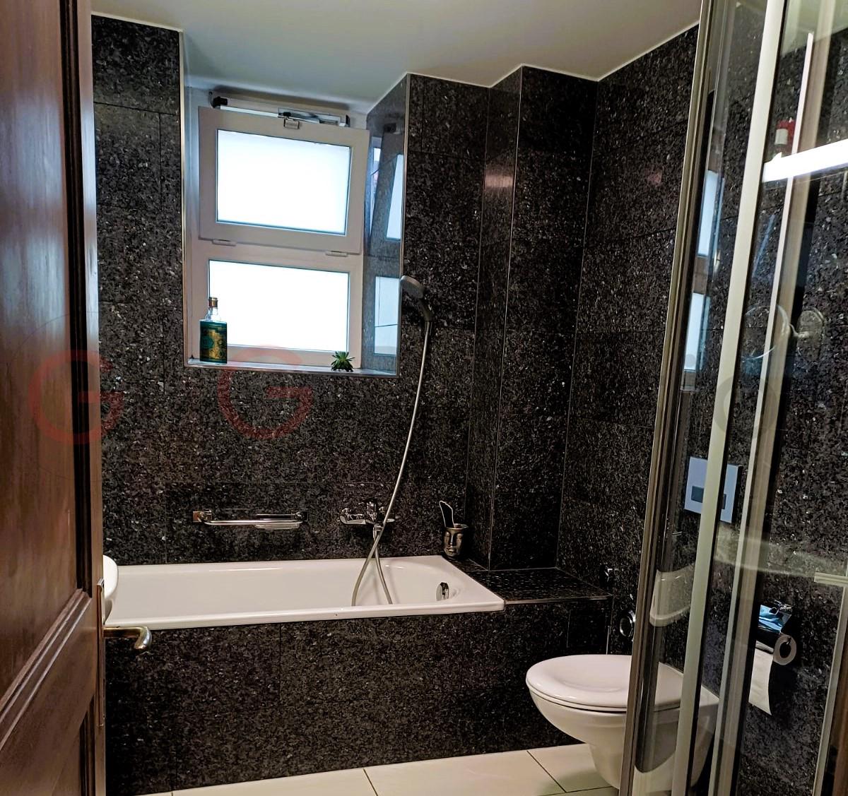Dunkles Badezimmer mit Badewanne und WC