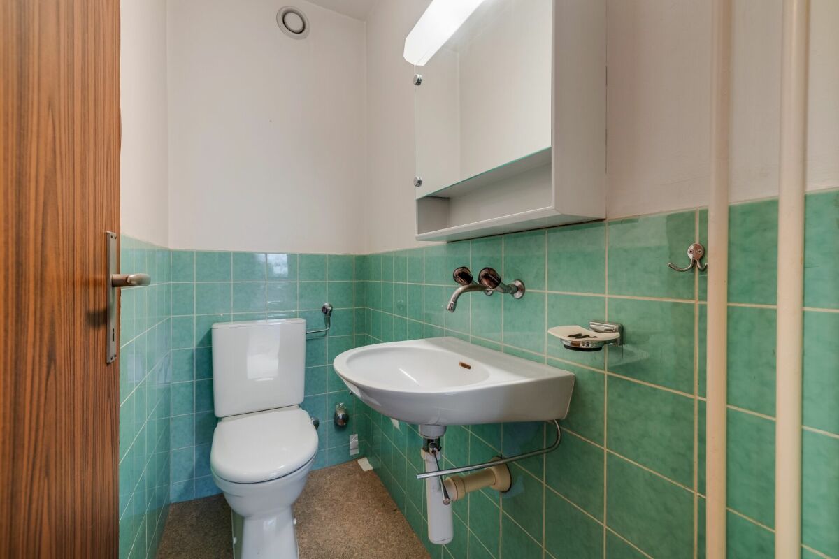 Kleines Gäste-WC mit grünem Fliesenspiegel