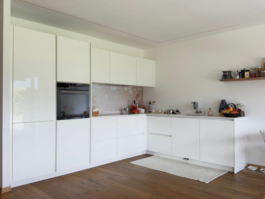Moderne weiße Küche mit Holzfußboden