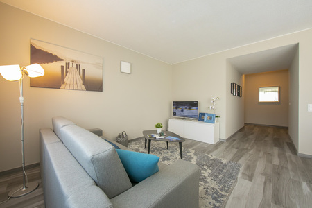 Modern eingerichtetes Wohnzimmer mit Flurblick