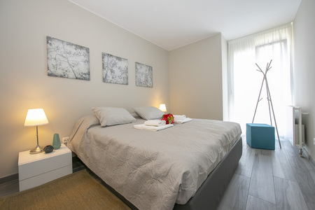 Helles Schlafzimmer mit Doppelbett und Balkontür