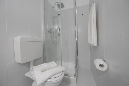 Kleines weißes Badezimmer mit Dusche und WC