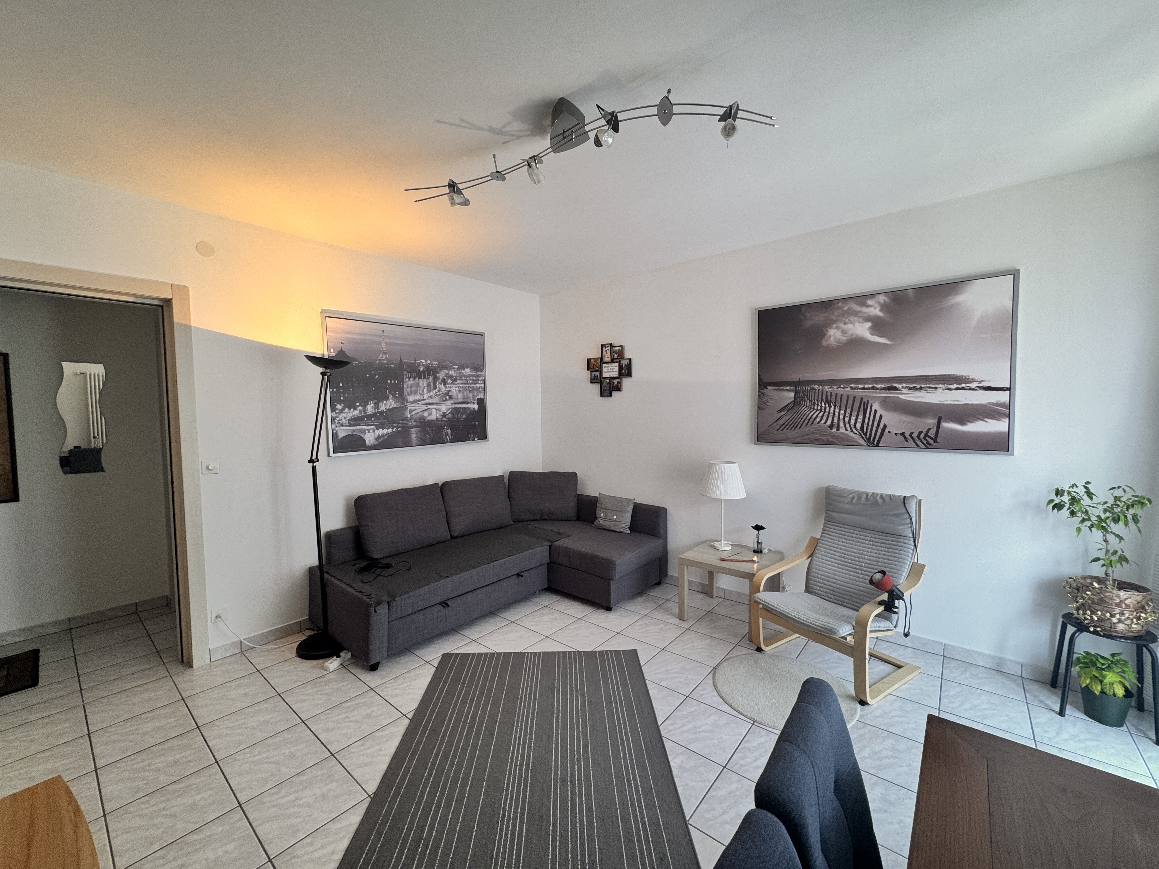 Wohnzimmer mit Sitzgruppe und Fliesenboden