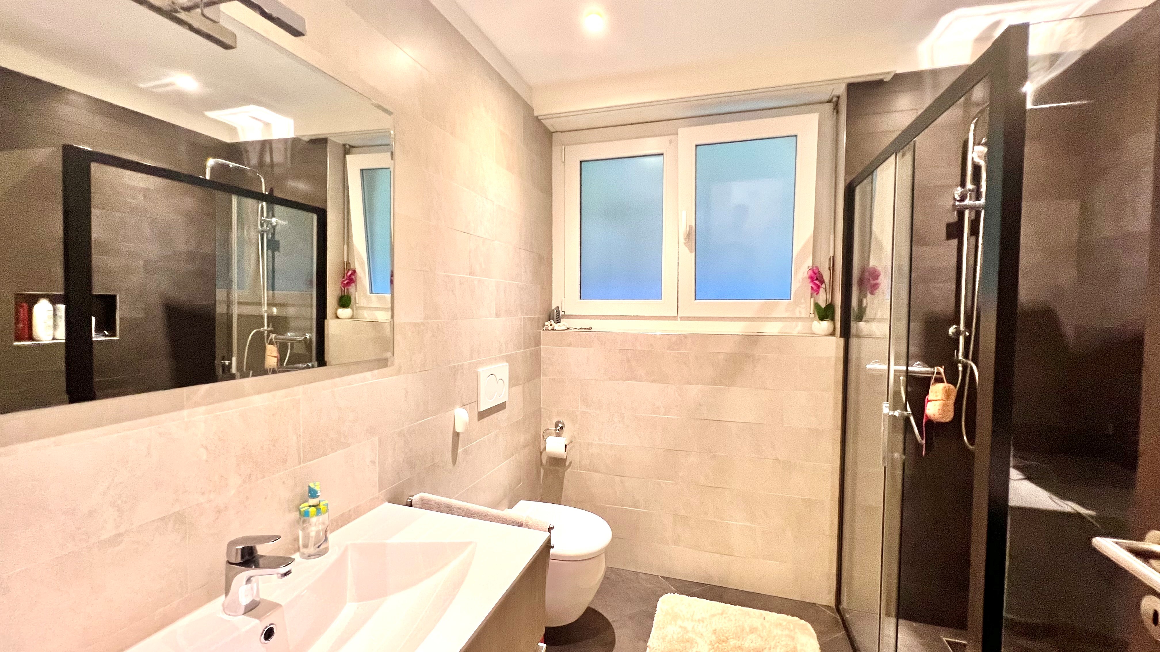Modernes Badezimmer mit Dusche und Fenster