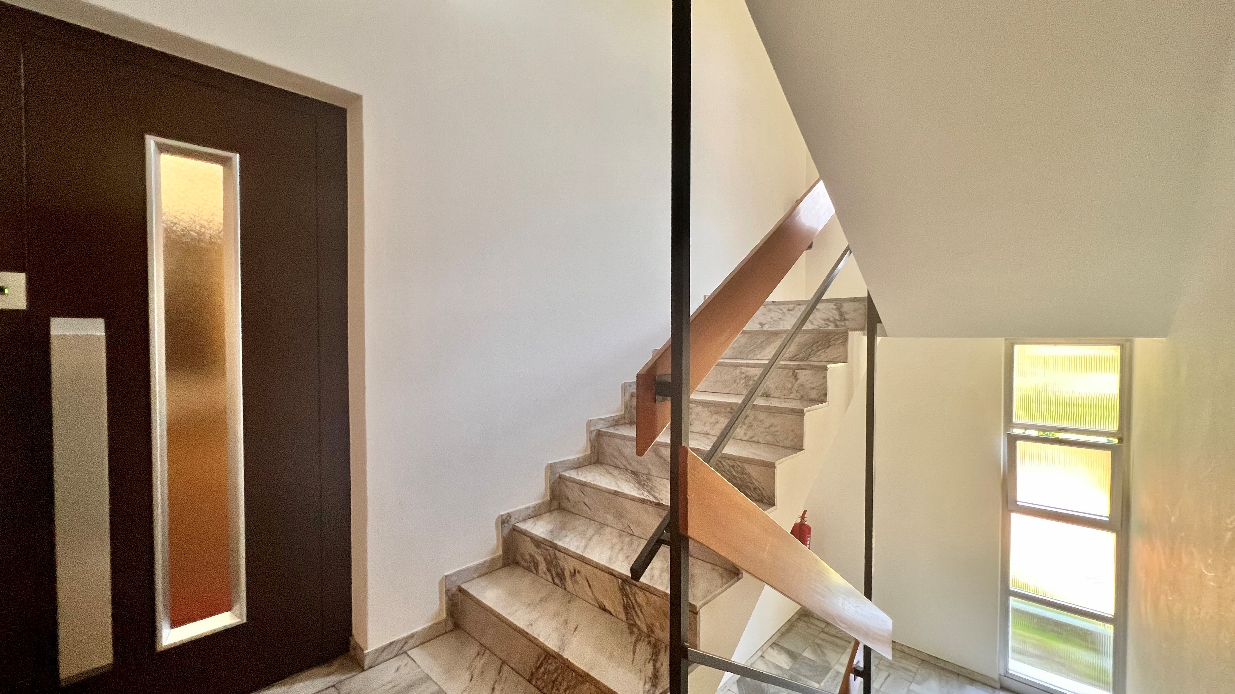 Treppenhaus mit dunkler Eingangstür
