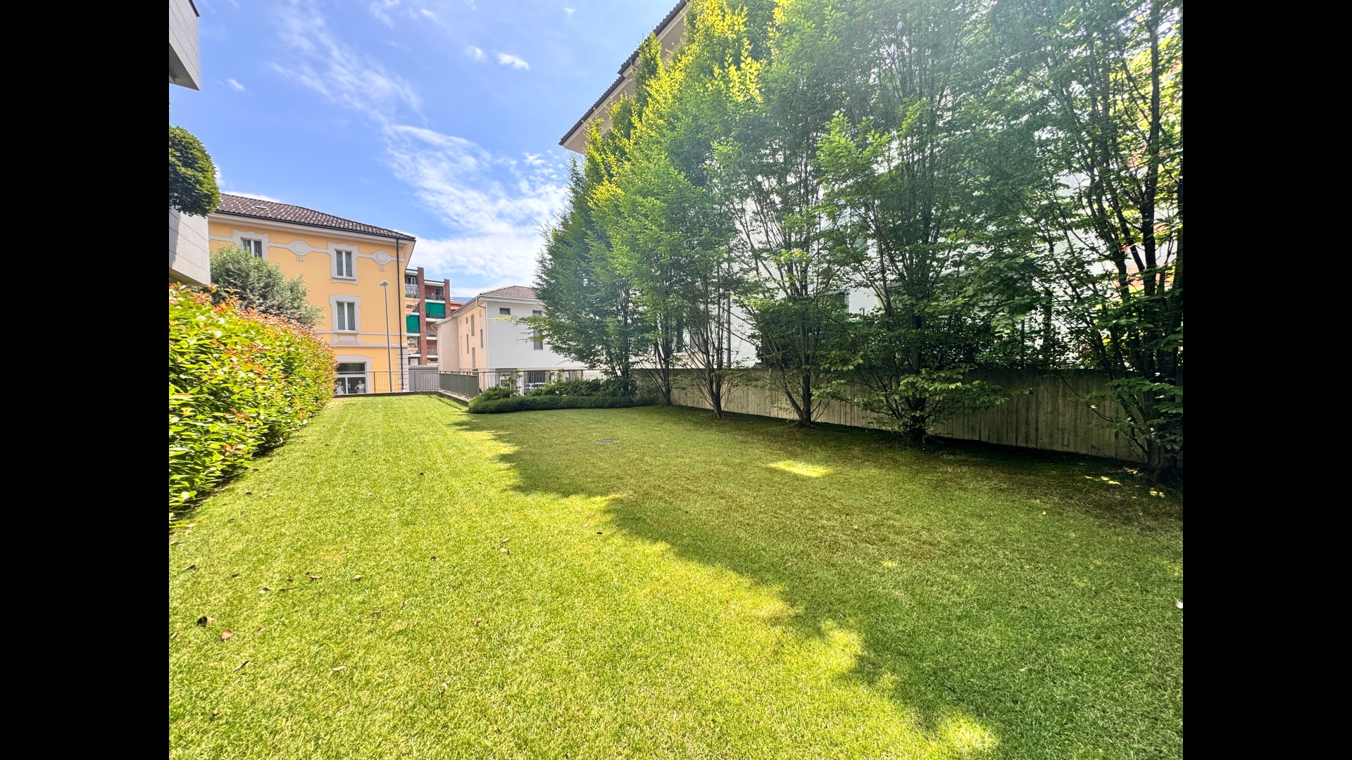Garten mit Rasenfläche zwischen Wohngebäuden