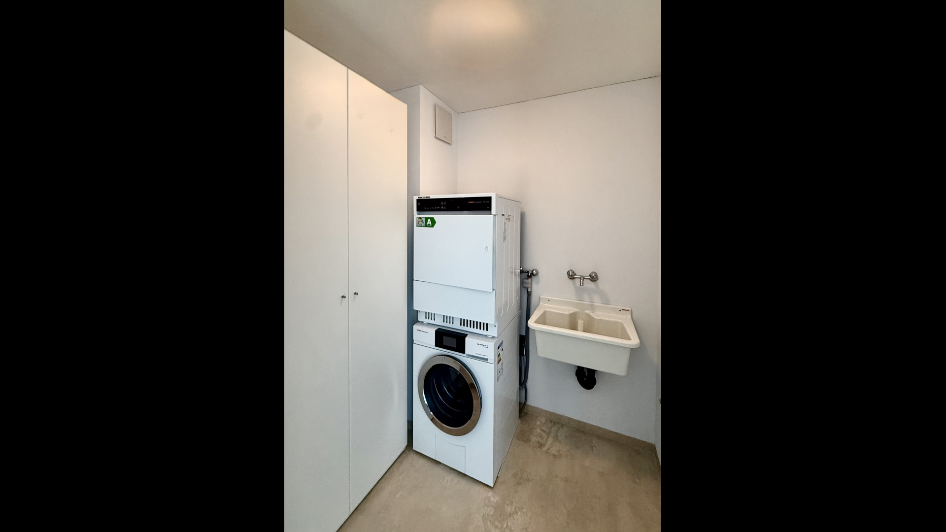 Hauswirtschaftsraum mit Waschmaschine und Waschbecken