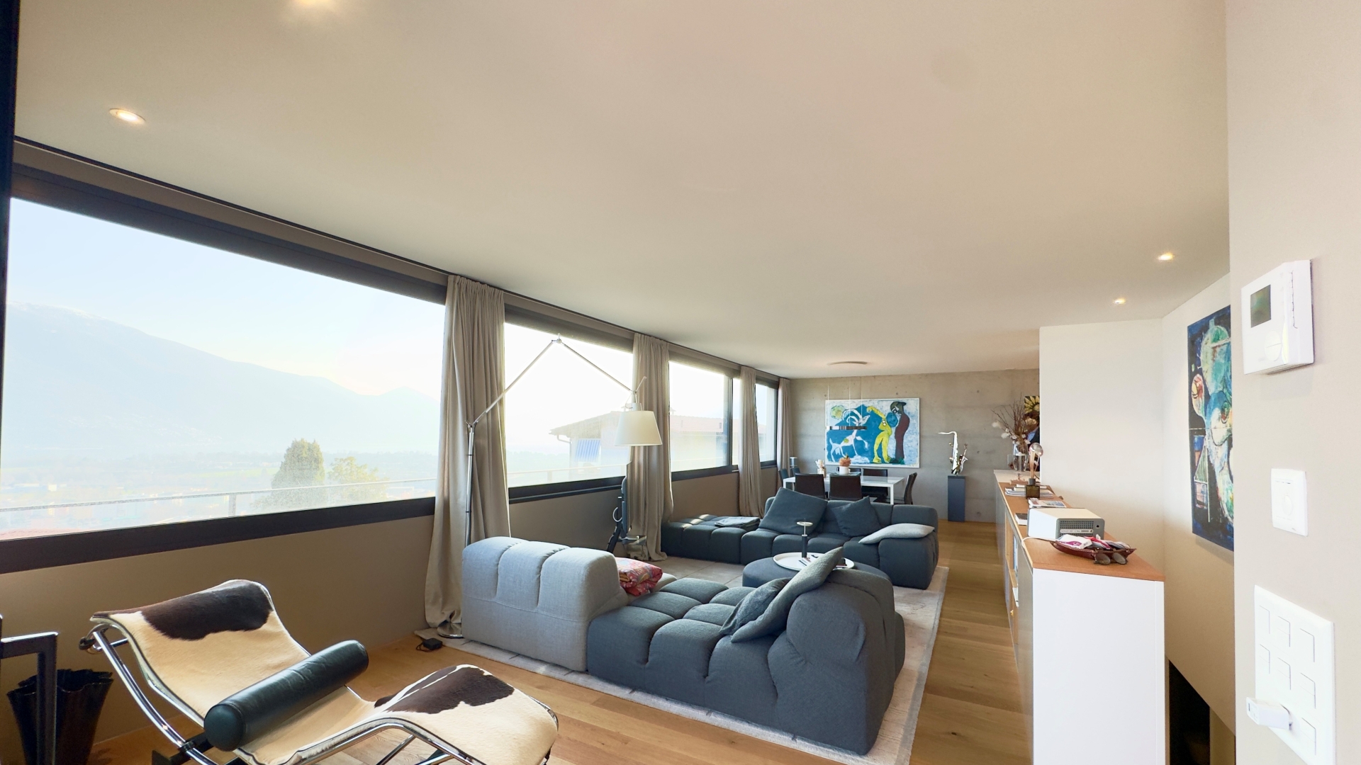 Helles Wohnzimmer mit Panoramafenstern und Bergblick