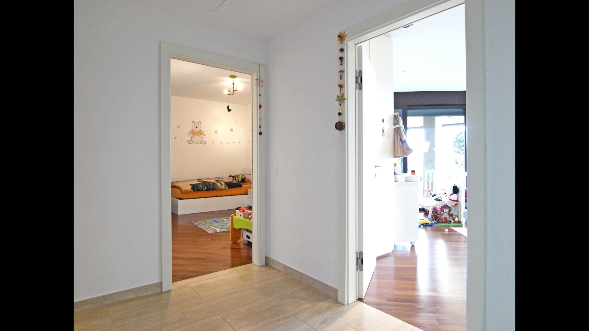 Heller Flur mit Blick in zwei Kinderzimmer