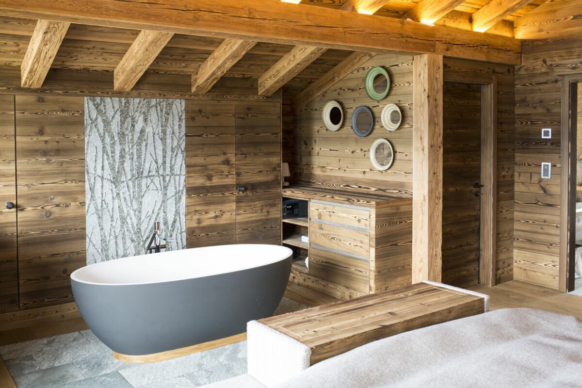 Rustikales Bad mit Holzverkleidung und freistehender Wanne