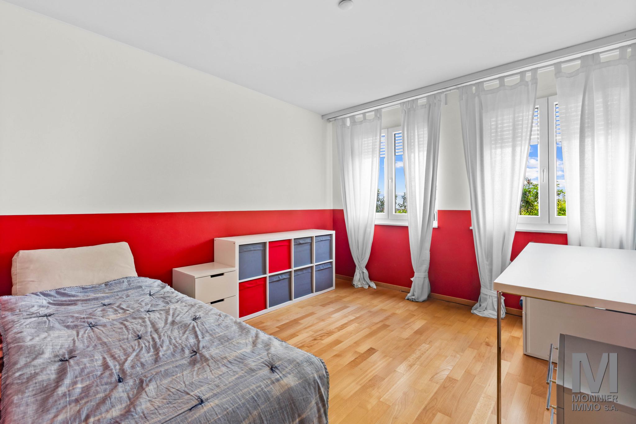 Helles Schlafzimmer mit roter Akzentwand
