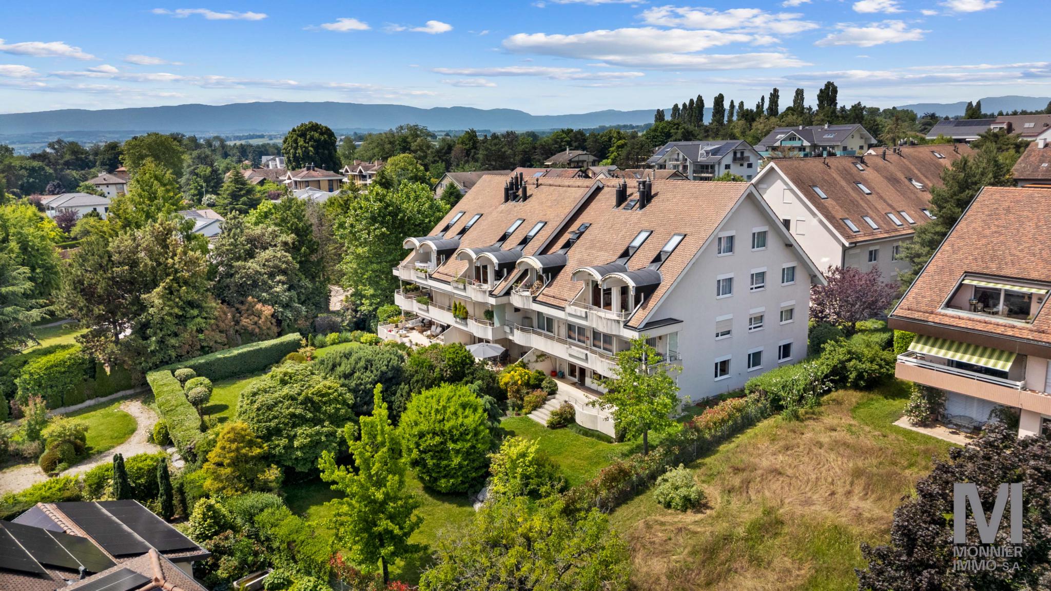 Luftaufnahme einer Wohnanlage mit Garten und Bergblick