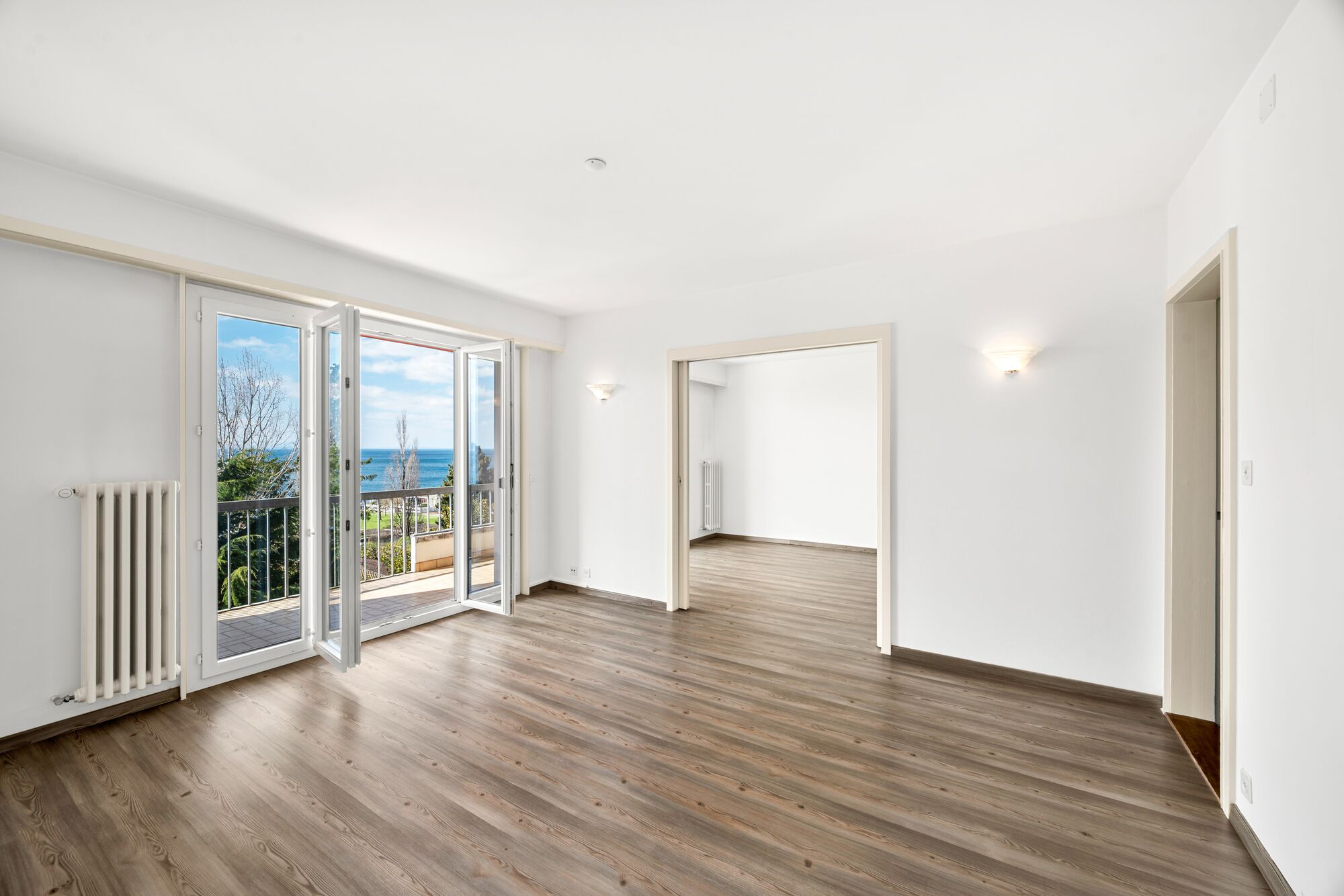 Heller leerer Wohnraum mit Balkon und Meerblick