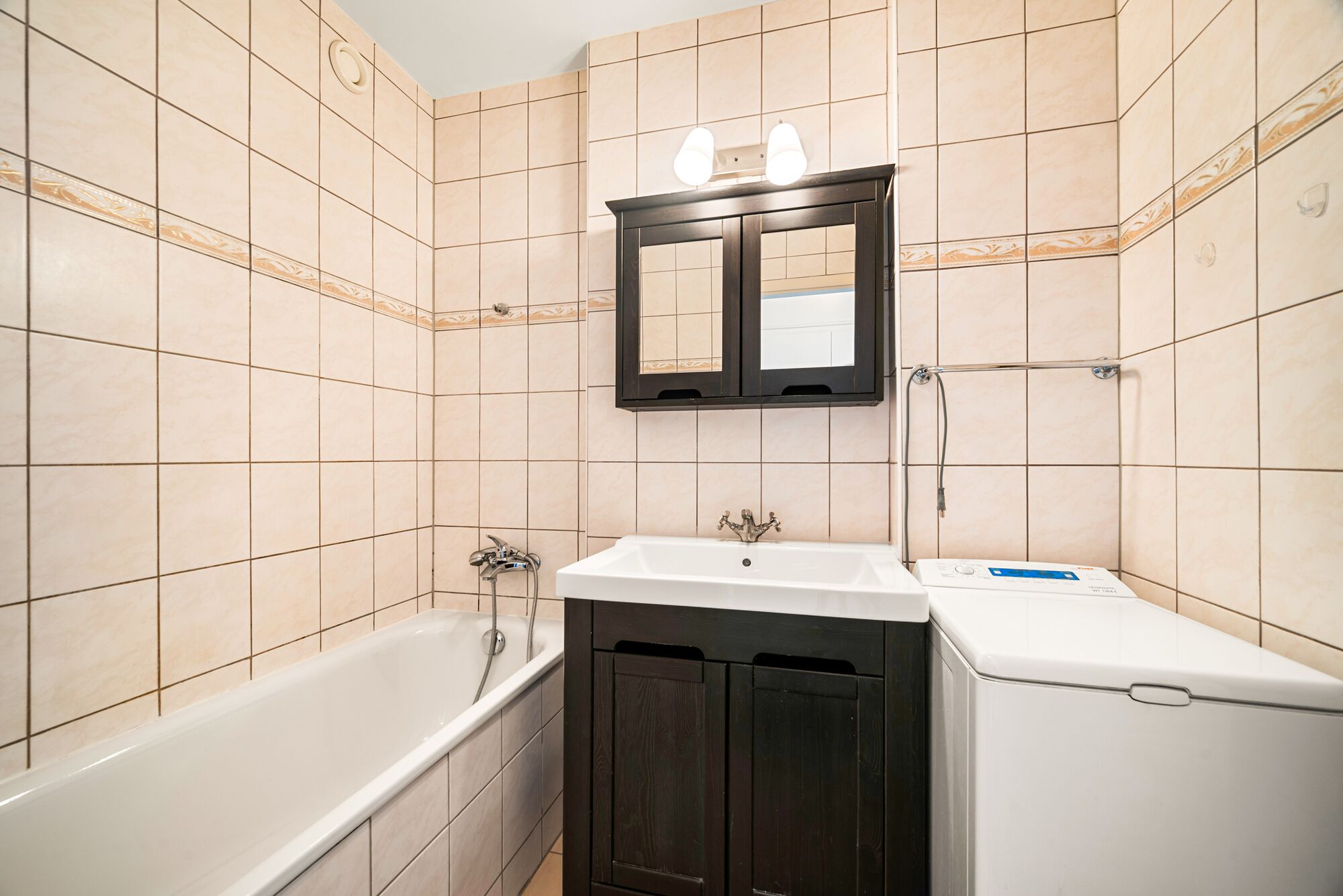 Kleines Bad mit Badewanne und Waschbereich