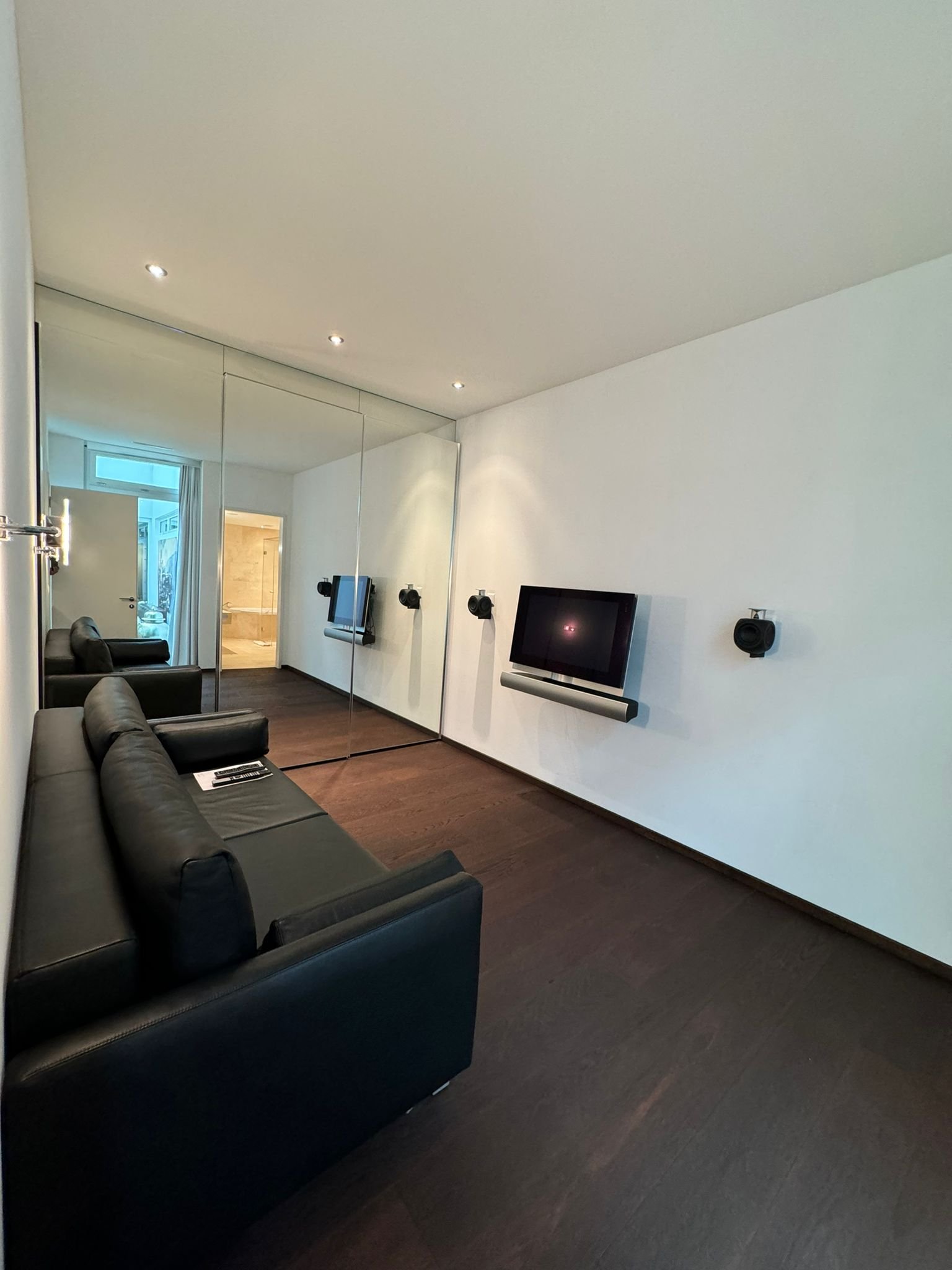 Modernes Wohnzimmer mit Wandspiegel und TV