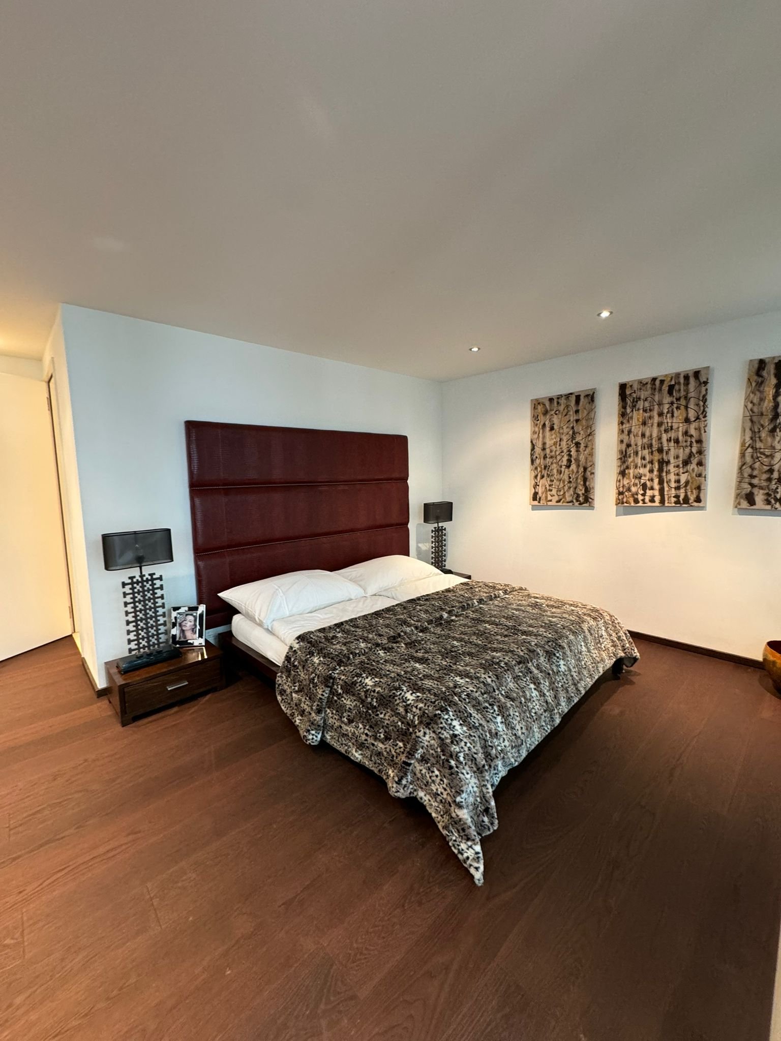 Modernes Schlafzimmer mit dunklem Holzboden