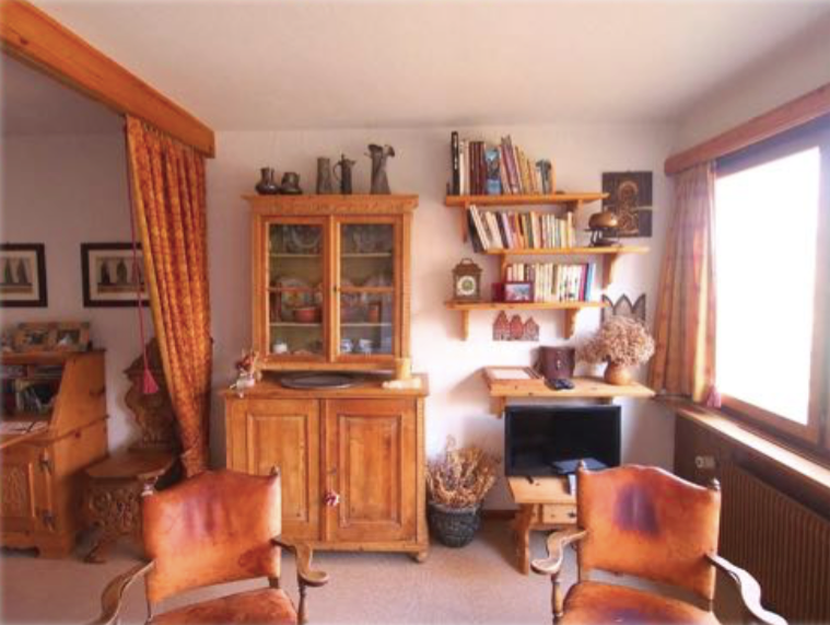 Wohnzimmer mit Holzvitrinen und Bücherregalen