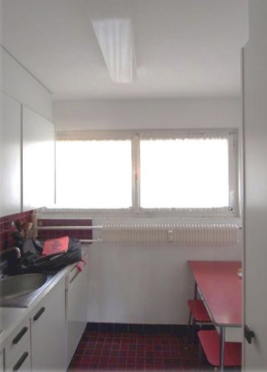 Kleine, schlicht eingerichtete Küche mit Fensterfront