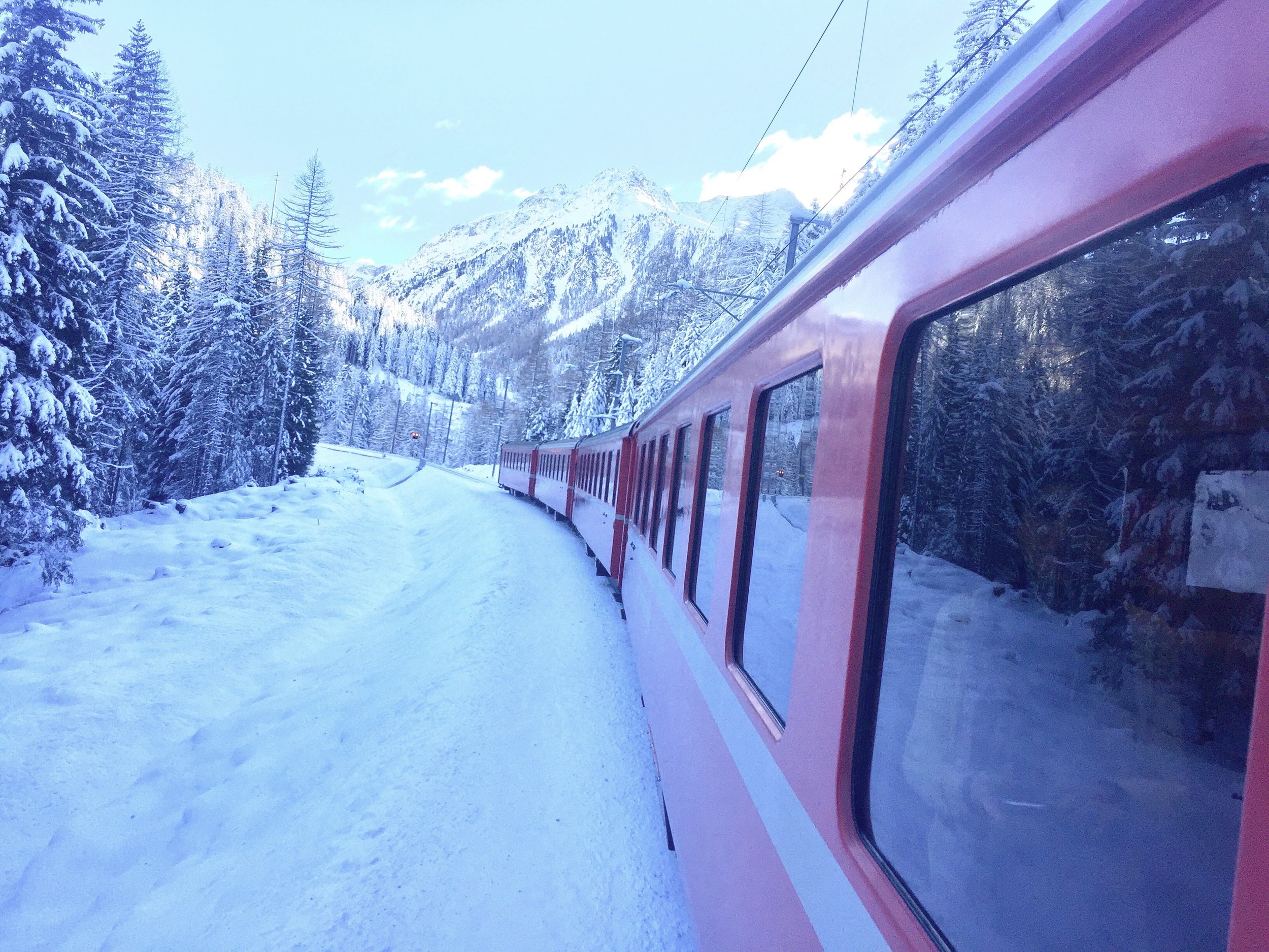 Zugfahrt durch verschneite Alpenlandschaft