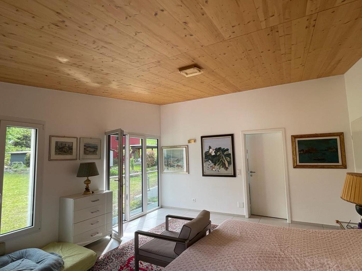 Helles Schlafzimmer mit Holzdecke und Gartenzugang