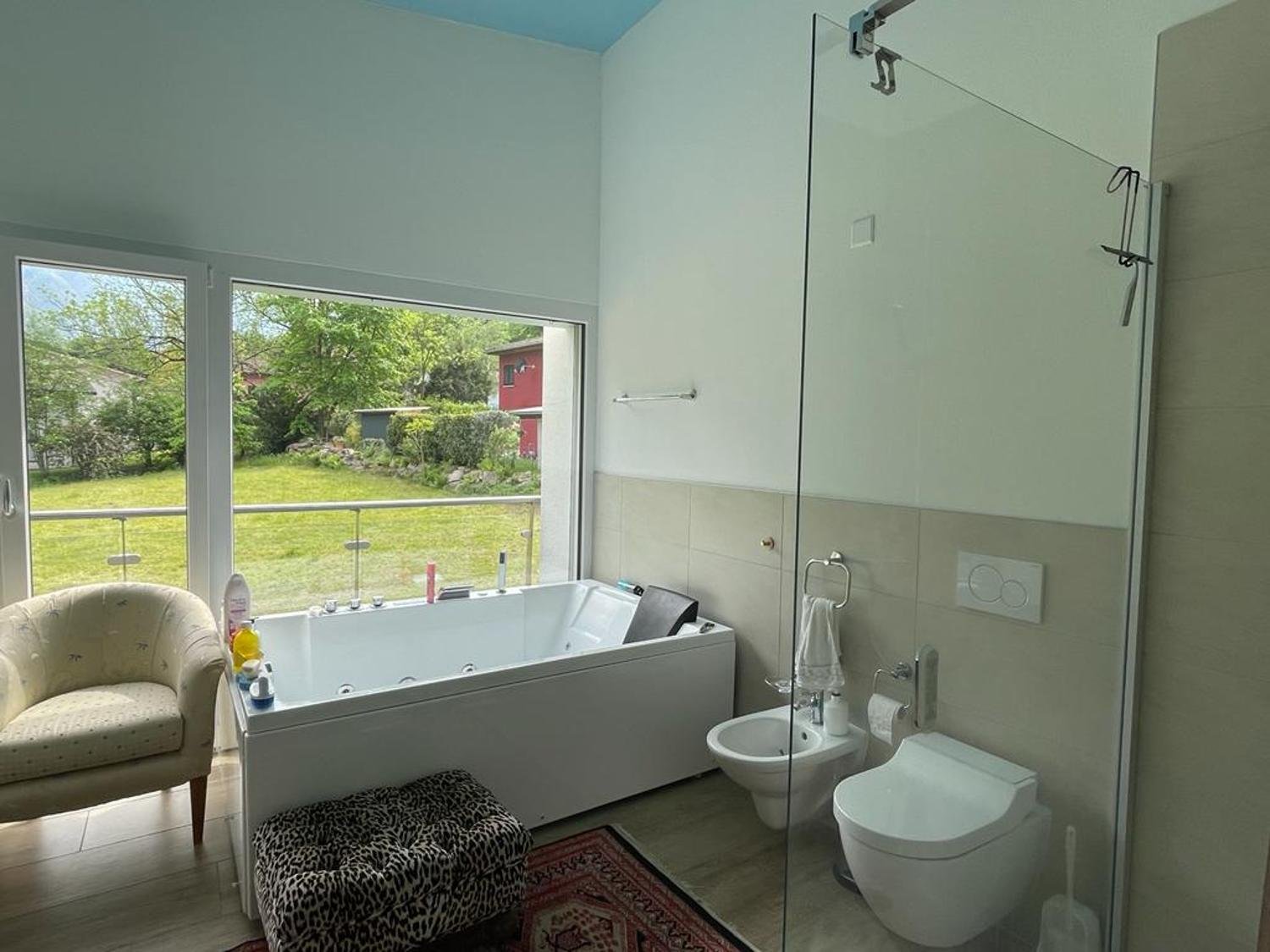 Modernes Badezimmer mit großer Fensterfront und Whirlpoolwanne