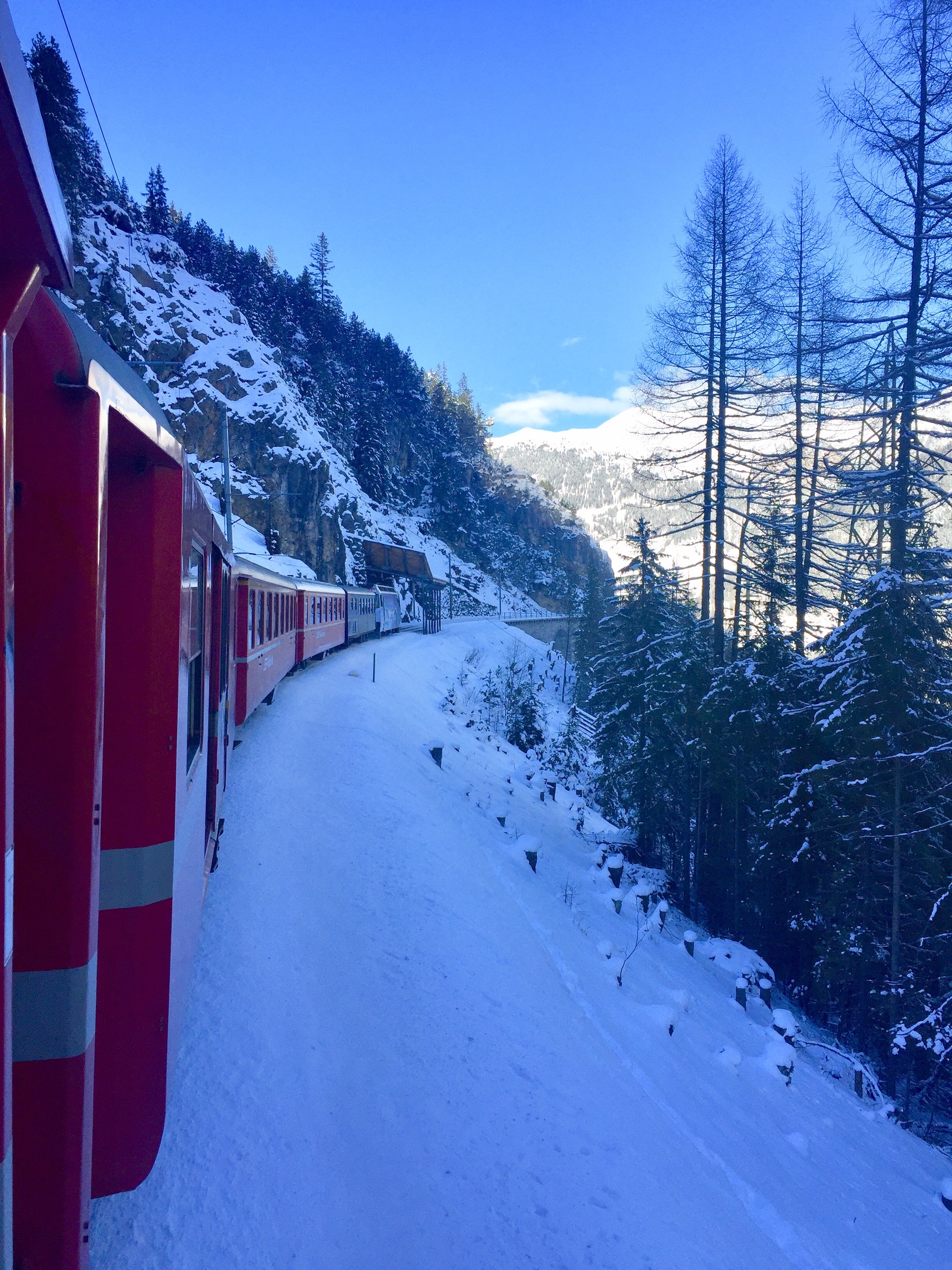 Zug im verschneiten Alpenpanorama
