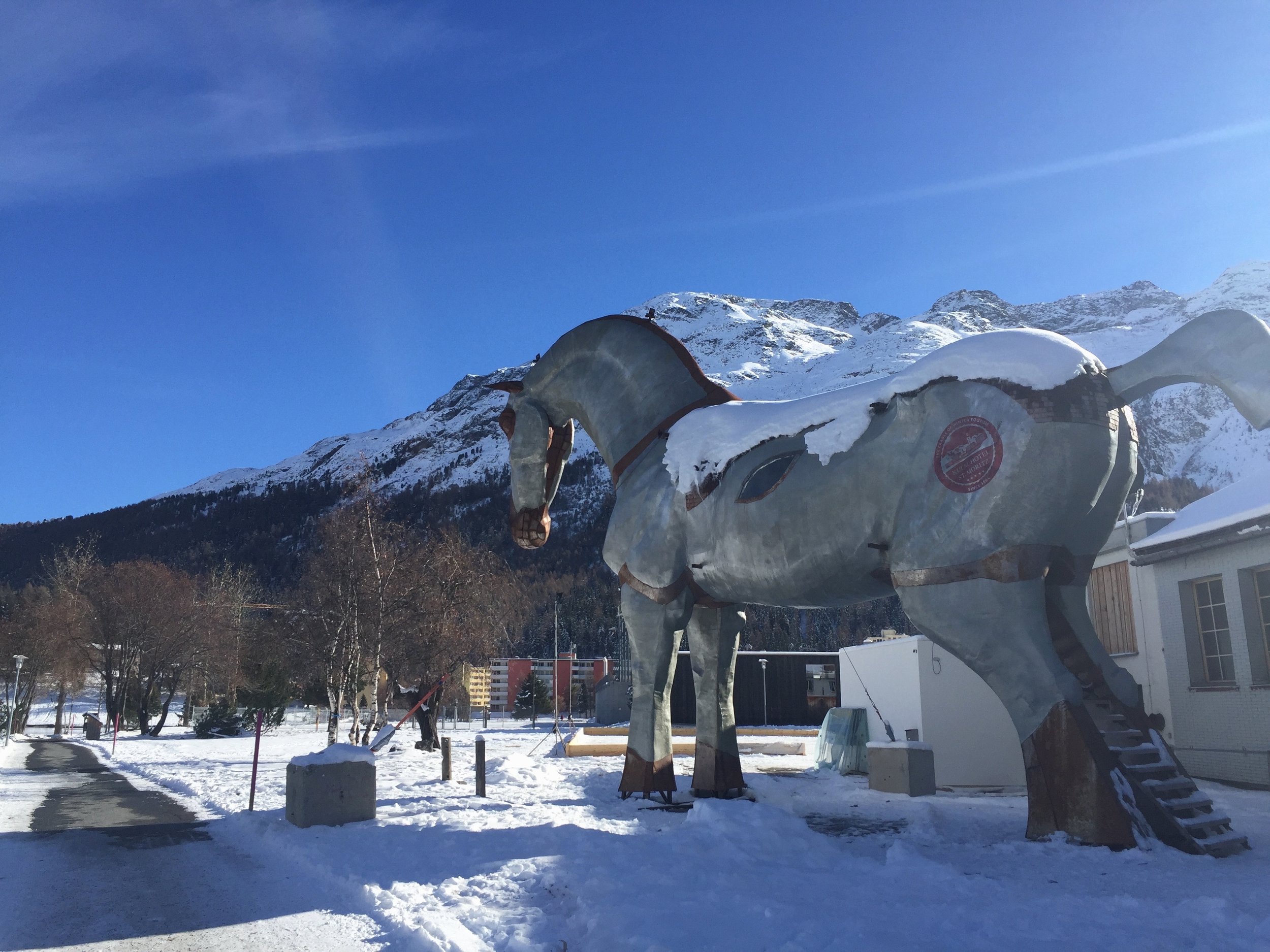 Große Pferdestatue im Schnee vor Bergkulisse