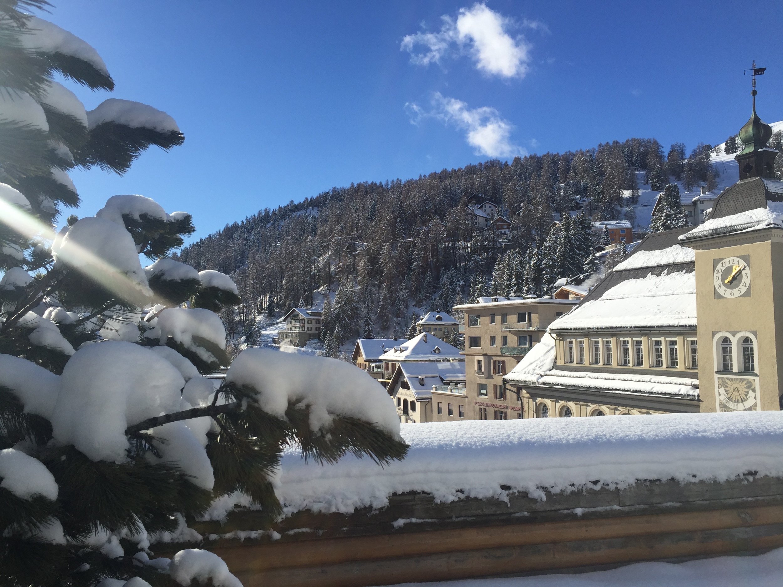 Schneebedeckte Alpenstadt mit Kirchturm