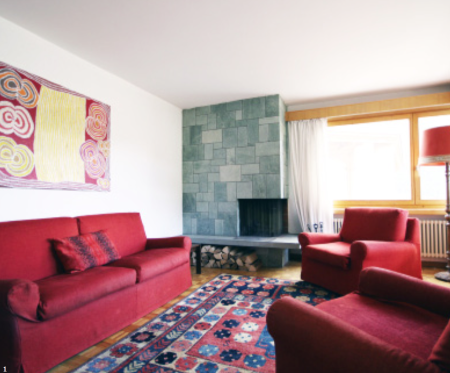 Gemütliches Wohnzimmer mit Kamin und roten Sitzmöbeln