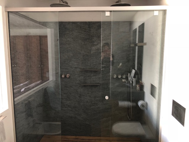 Modernes Badezimmer mit dunkler Glasdusche